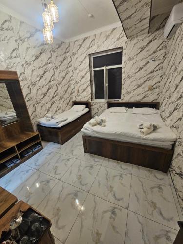 two beds in a room with a stone wall at Turg'unTown in Toshkent-Passajir Bekati