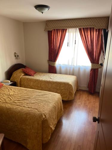 a hotel room with two beds and a window at DUNA Apart Hotel in Copiapó