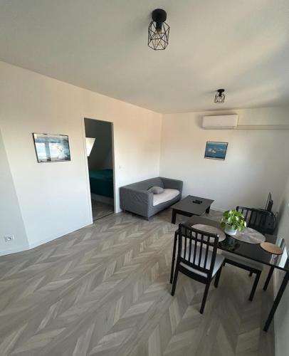 a living room with a couch and a table at Cosy appartement in Miniac-Morvan