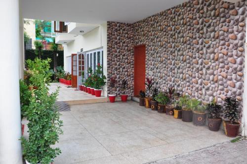 a building with potted plants and a stone wall at Alaf Laila Guest House in Abbottābād