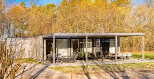 a small house with a table and chairs at Forest Villa 8 persons #724 in Maasbree