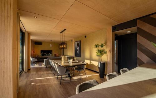 a dining room and living room with a table and chairs at Forest Villa 8 persons #724 in Maasbree