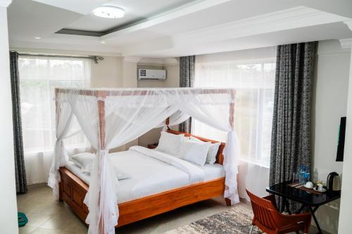 a bedroom with a bed with a canopy at Kitobo Serenity Resort in Arusha