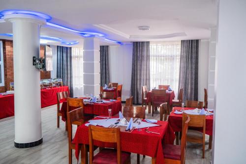 a restaurant with tables and chairs with red table cloth at Kitobo Serenity Resort in Arusha