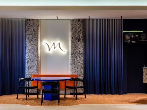 ein Esszimmer mit einem blauen Tisch und Stühlen in der Unterkunft Mercure Gdynia Centrum in Gdynia