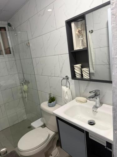 a white bathroom with a toilet and a sink at Los Alcarrizos Puente Blanco Urban Oasis ubicado en la calle 22 numero 98 los alcarrizos in Santo Domingo