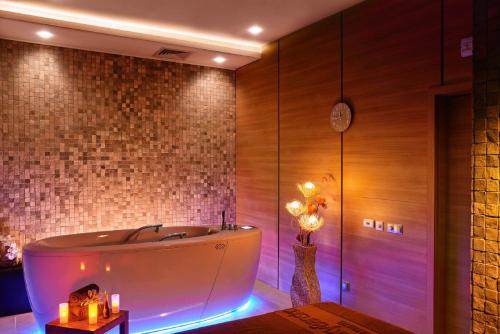 a bath tub in a room with a brick wall at Lucky Bansko Aparthotel SPA & Relax in Bansko