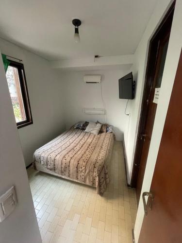 a small bedroom with a bed in a room at Private room with bathroom in Mendoza