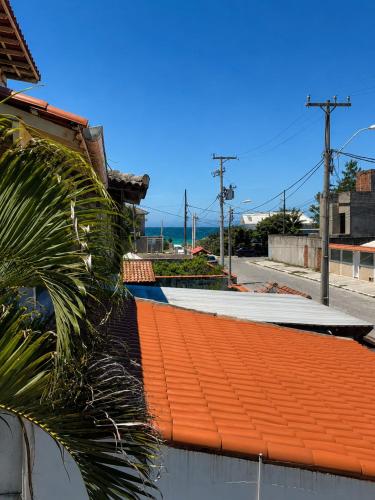 an orange roof on a building with a palm tree at Casa Estelar in Cabo Frio