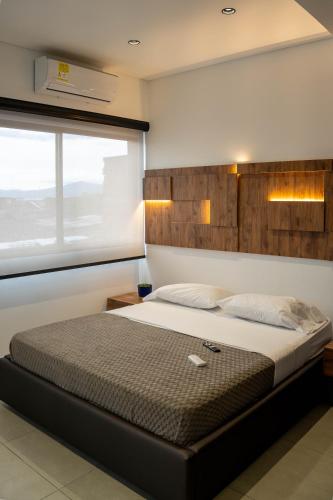 a bedroom with a large bed with a window at Patio Alto Rooftop in Buga