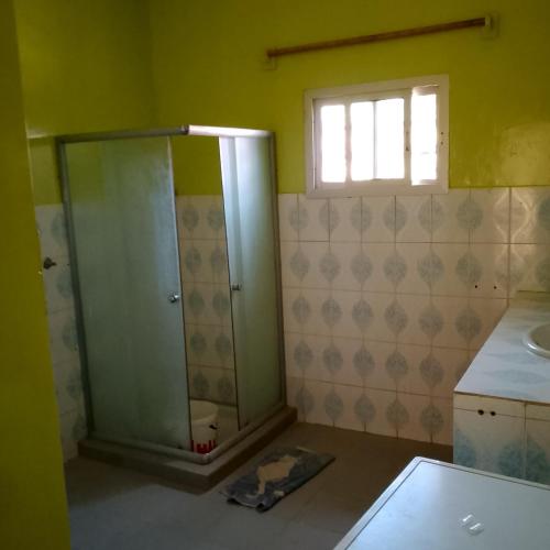 a bathroom with a shower and a sink at Keur Diédhiou in Saly Portudal