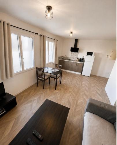 a living room with a table and a kitchen at Cosy appartement in Miniac-Morvan