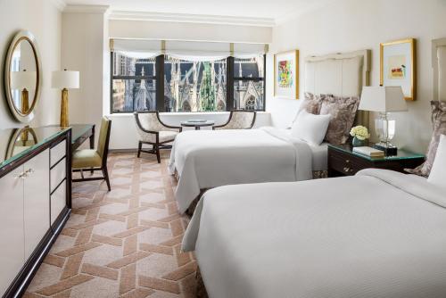 a hotel room with two beds and a table at Lotte New York Palace in New York