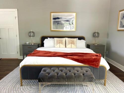 a bedroom with a large bed with a red blanket on it at The Legacy House in Topeka