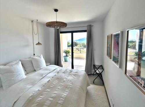 a bedroom with a white bed and a large window at Cosi Horizon in Grosseto-Prugna