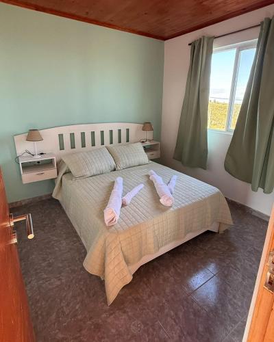a bedroom with a bed with pink slippers on it at Cuchac Cuchic in Las Compuertas