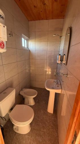 a bathroom with a white toilet and a sink at Cuchac Cuchic in Las Compuertas