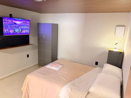 a bedroom with a bed and a flat screen tv at Hotel Santo Antonio in Botucatu