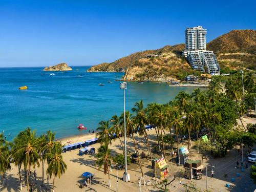 a view of a beach with palm trees and a building at Apartamento 10c Edf.Playa in Santa Marta