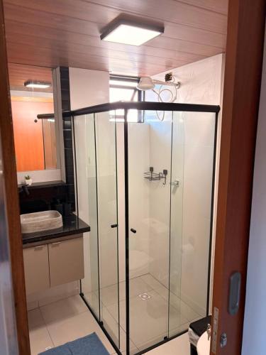 a glass shower in a bathroom with a sink at Hotel Santo Antonio in Botucatu