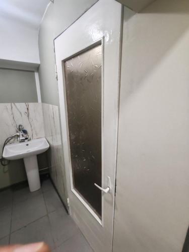 a bathroom with a shower door and a sink at MG guest house in Geghanist