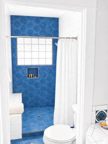 a blue bathroom with a toilet and a shower at The Edgewater in Avalon