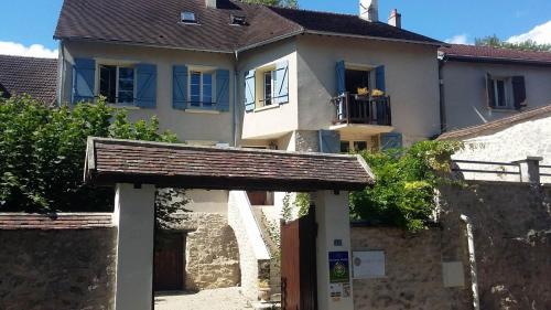 ein Haus mit einem Tor vor einem Gebäude in der Unterkunft Chambres d'hôtes Villa de Vienne-en-Arthies in Vienne-en-Arthies