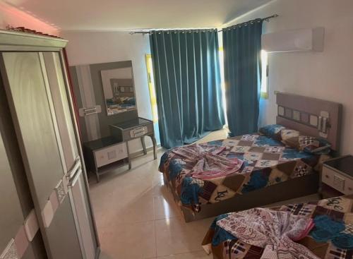 a large bedroom with two beds and a mirror at فيلا بسين خاص in Dawwār Abū Maḩrūs