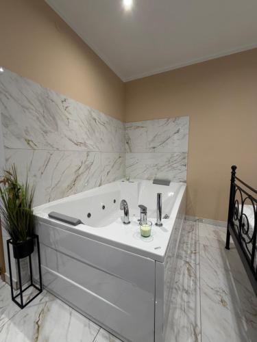 a white bath tub in a bathroom with marble walls at La Dolce Vita in Piran