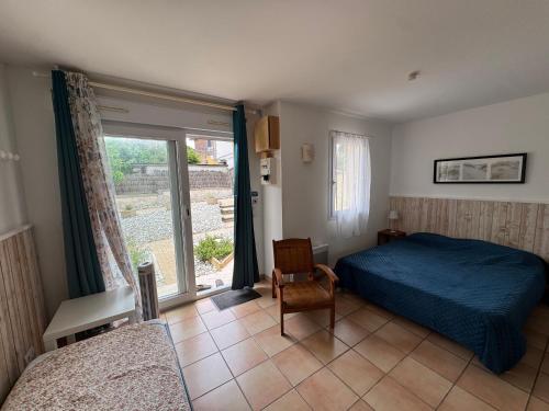 a bedroom with a bed and a window and a chair at Résidence le patio - Mimizan plage in Mimizan-Plage
