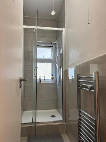 a glass shower in a bathroom with a window at Clare - Double Room 20 mins walk to centre -Kitchenette Smart TV Shared bathroom in Chesterton