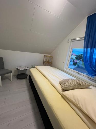 a bedroom with a large bed and a window at Great Guest House Natalie's in Skjervøy