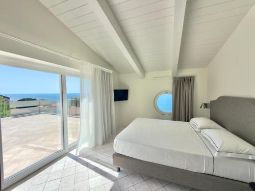 a bedroom with a large bed and a balcony at Borgo dei Saraceni - Domus Indomita in Agropoli