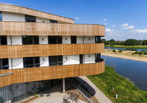 an external view of a building next to a river at Das ELB Hotel & Restaurant in Magdeburg