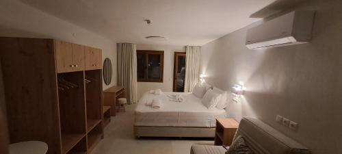 a bedroom with a white bed and a room with a window at Calm And Nature in Petra