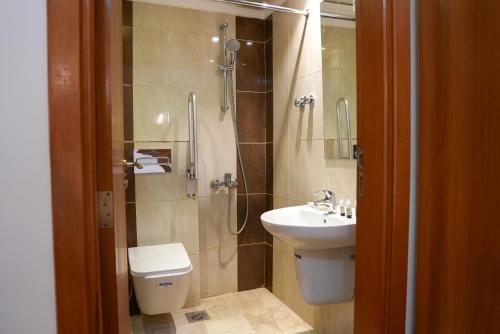 a bathroom with a toilet and a sink and a shower at فندق بالم بوتيك مكة in Az Zahrāʼ