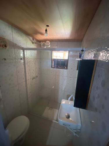 a bathroom with a toilet and a sink at Pouso do caiçara suíte fundo do mar in Paraty
