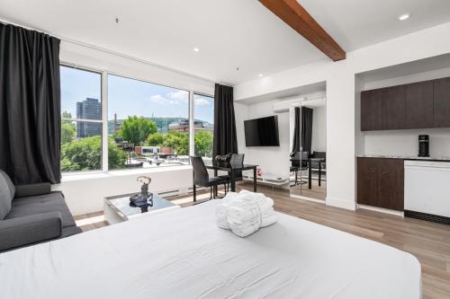 a bedroom with a white bed and a living room at Bonjour Plateau Hotel in Montreal