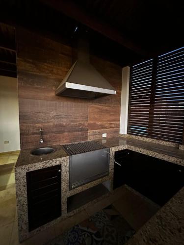 a kitchen with a stove and a sink at Luxury Duplex Terrace and Grill in Ica