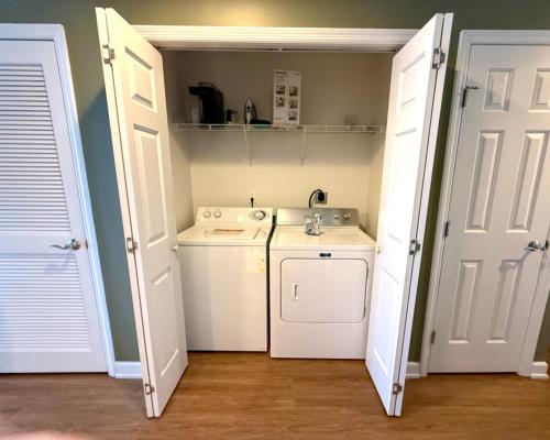 a small kitchen with a sink and a washing machine at Gulf-Front Paradise, Steps to Beach & Pool Access in Panama City Beach