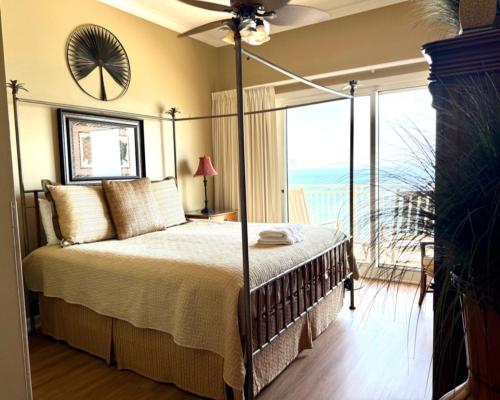 a bedroom with a bed with a view of the ocean at Gulf-Front Paradise, Steps to Beach & Pool Access in Panama City Beach