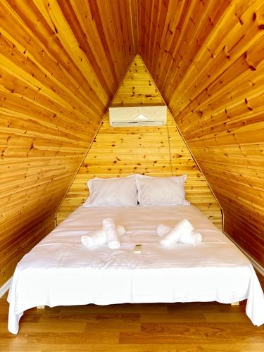 a bedroom with a bed in a wooden room at Camping Temali T&M in Arrëz