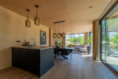 a kitchen and living room with a table and chairs at Forest Villa 6 persons #1212 in Maasbree