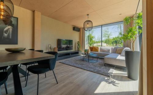a living room with a couch and a table at Forest Villa 6 persons #1212 in Maasbree