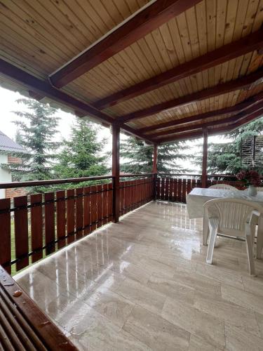 a large wooden deck with a table and chairs at Villa JETI in Tetovo