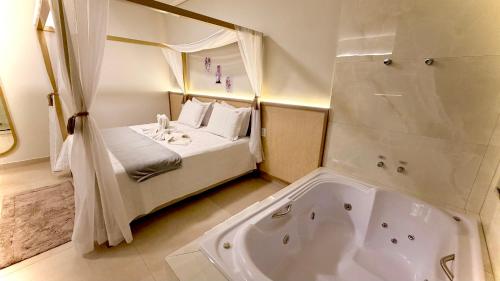 a bathroom with a bed and a bath tub at Hotel & Pousada Recanto do Sabiá in Pirapora
