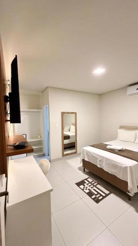 a bedroom with a bed and a television in it at Hotel & Pousada Recanto do Sabiá in Pirapora
