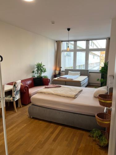 a room with two beds and a living room with a couch at Conscious Stay - Mindful Living in Berlin