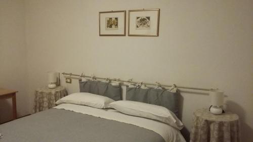a bedroom with a bed with two tables and two pictures on the wall at Agriturismo Boschi in Reggiolo