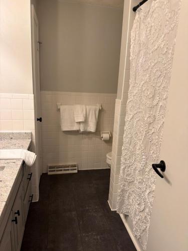 a bathroom with a shower with a white shower curtain at The Massillon Retreat! in Massillon